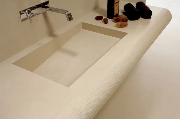 Elegantes Badezimmer mit beigen Natursteinfliesen und massivem Natursteinwaschtisch